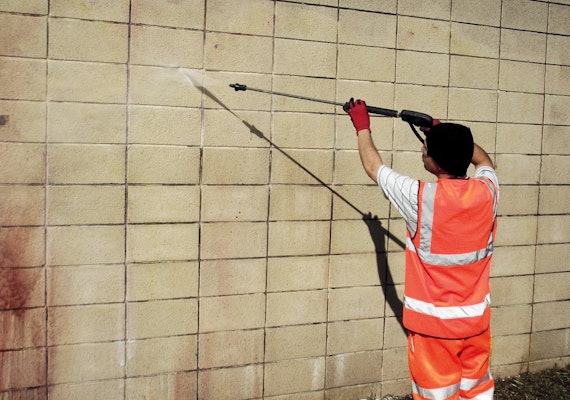 A security expert removing graffiti from a property